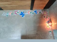 an overhead view of a decorated floor with a lit candle in the center and flowers painted on it