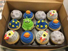 a box filled with lots of cupcakes covered in frosting and decorated like animals