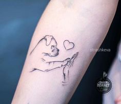 a tattoo on the arm of a person holding a dog's paw and heart