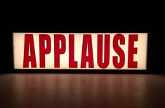 an illuminated sign that says applause