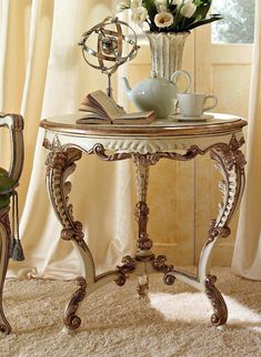 a vase with flowers on top of a table next to a chair