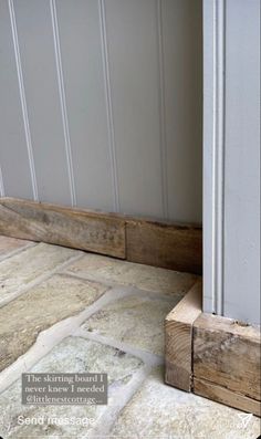 a cat is sitting on the floor next to an open door and some wood planks