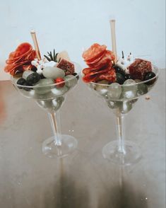 two glasses filled with different types of food on top of a table next to each other