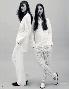 two women standing next to each other in white clothing