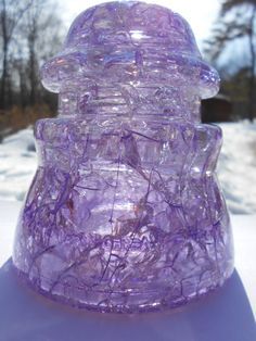 a purple vase sitting on top of snow covered ground