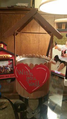 a heart shaped bucket sitting on top of a glass table next to a framed photo