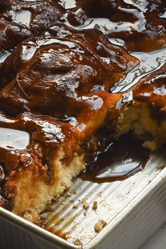 a close up of a piece of cake in a pan with caramel sauce on it