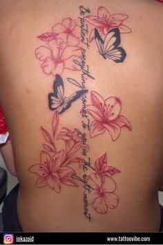 a woman's back with flowers and butterflies on her lower back, the words are written in cursive writing