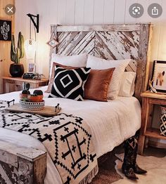 a bed with pillows, blankets and lights on it in a room that has wood paneled walls