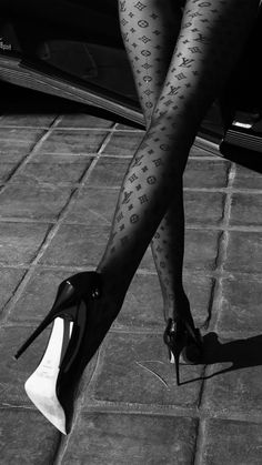 a woman's legs with tattoos and high heels