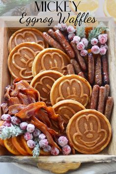 a wooden box filled with cookies and pretzels on top of a table next to orange slices