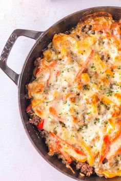 a skillet filled with cheese and meat covered in sauce