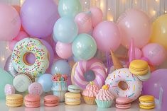 a table topped with lots of donuts and balloons