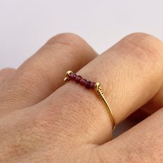 This beautifully simple ring is lovingly handmade with 5 tiny Garnet gemstones and a choice of 14k Gold Filled, 14k Rose Gold Filled or Sterling Silver band. M A T E R I A L S: * Garnet * 14k Gold Filled, 14k Rose Gold Filled or Sterling Silver S I Z E: *  Gemstone - Approximately 2mm each *  Band Thickness - Approximately 0.8-1mm  All of our jewellery is carefully handmade using good quality materials and handpicked gemstones, with the aim to produce quality pieces that you can love & wear for 14k Gold Filled Gemstone Rings For Gift, Gift Gemstone Rings In 14k Gold Filled, Adjustable Ruby Birthstone Ring In Fine Jewelry Style, Adjustable Ruby Birthstone Ring, Fine Jewelry, Elegant 14k Gold Wire Wrapped Rings, Elegant Everyday Wire Wrapped Rings, Minimalist Stackable Ruby Ring In Yellow Gold, Handmade Dainty 14k Gold Midi Rings, Adjustable Dainty Ruby Promise Ring