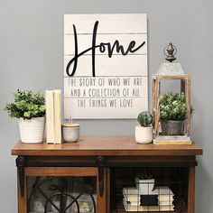 a shelf with some plants on top of it next to a sign that says home