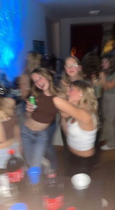 a group of young women standing around each other in front of a table full of cups