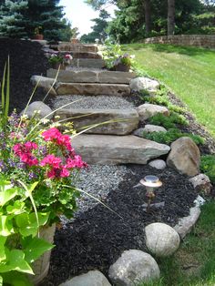 a garden with rocks and flowers in it