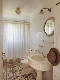 a bathroom with a sink, toilet and shower curtain in it's doorway area