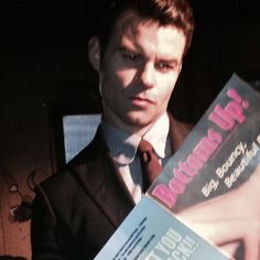 a man holding two books in his hands