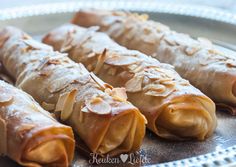 some food is on a silver plate and it looks like they have been rolled up