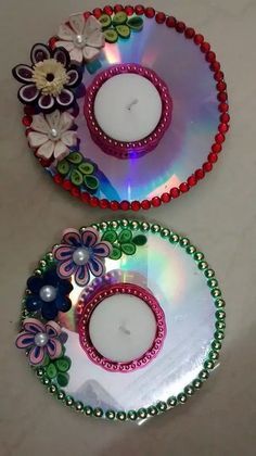 two decorative plates with flowers on them sitting on a counter top next to each other