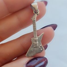 Product Description: This handmade 925 Sterling Silver Electric Guitar Pendant is a truly remarkable piece, meticulously crafted to resemble a real electric guitar. Its accuracy in details makes it an ideal gift for guitar players and music enthusiasts alike, perfect for occasions such as birthdays, anniversaries, or just to show appreciation to a fellow musician. Highlights: - Handmade item - Made with 925 Sterling Silver - Immaculately detailed - Dispatches from a small business in Greece  Ben Silver Rock Style Jewelry, Silver Rock Style Necklace Gift, Silver Rock Style Necklace As Gift, Silver Rock Style Necklace For Gift, Sterling Silver Jewelry For Concerts, Guitar Pendant, Guitar Players, Gift For Music Lover, Electric Guitars