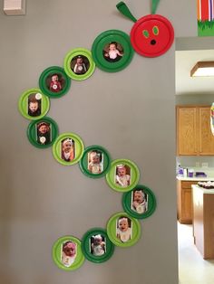 the wall is decorated with green and red plates that have pictures of babies on them