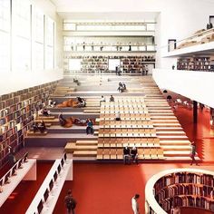 an empty library filled with lots of books and people sitting on benches in front of them