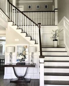 the stairs in this house are decorated with white and black accents, along with flowers