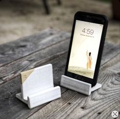 a cell phone sitting on top of a wooden table next to a paper holder and stand