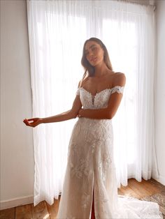 a woman in a white wedding dress is posing for the camera with her arms outstretched