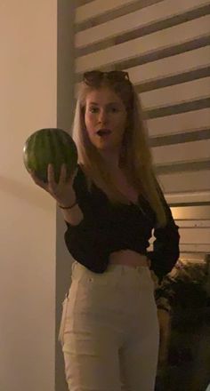 a woman holding a watermelon in her right hand