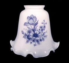 a blue and white vase with flowers on it's side against a black background