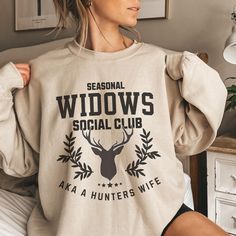 A funny seasonal widows social club sweatshirt for ladies who are abandoned during hunting season. This cozy and durable sweatshirt provides a comfy wearing experience with a clean-cut style, perfect for the colder months. It is relevant to women looking for a humorous and relatable seasonal design to wear during hunting season. Product features - Made with a medium-heavy fabric blend of 50% cotton and 50% polyester for coziness - Ribbed knit collar with seam for elasticity and shape retention - No side seams for reduced fabric waste and attractive look - Double-needle stitching for added durability - Ethically grown US cotton and OEKO-TEX-certified dyes for sustainability Care instructions - Machine wash: cold (max 30C or 90F) - Non-chlorine: bleach as needed - Tumble dry: low heat - Do n Hunters Wife, Deer Hunting Season, Shirt For Ladies, Funny Hunting, Hunting Humor, Fabric Waste, Club Sweatshirts, Hunting Season, Hunting Shirts