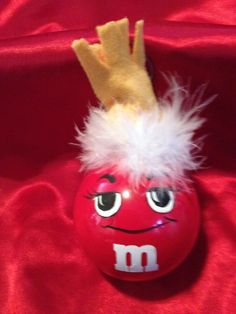 a close up of a red ball with a crown on it's head and eyes