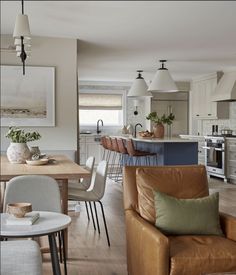 a living room filled with furniture next to a kitchen and dining room table in front of an oven