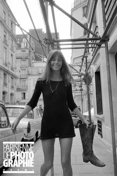 a woman is standing on the sidewalk with her legs spread out and holding an umbrella