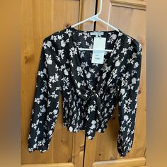 Long Sleeve Black And Floral Blouse. This Blouse Is A V-Neck Style With A Tie Front. It Has Cinched Detailing At The Bottom Making It Super Flattering. Bought This At A Local Boutique And Never Wore! Care, Content, And Details: Size S 100% Polyester Hand Wash Hang Dry Made In Cn 18.5” (Measurement Taken From Top Of Shoulder To Bottom Of Hem) Floral Print V-neck Top For Date Night, Black V-neck Blouse For Day Out, Floral Print V-neck Blouse For Date Night, White Crop Blouse, Flowy Sleeves, Love Tree, Tie Neck Blouse, Off Shoulder Sweater, Local Boutique