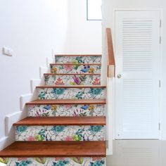 the stairs are painted with colorful flowers and leaves on them, as well as white shutters