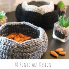 three crocheted baskets with plants in them on a table next to each other