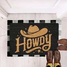 a man standing in front of a black and white door mat with the words hodgy on it