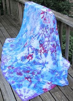 a blue and purple blanket sitting on top of a wooden deck