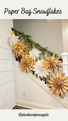 paper bag snowflakes are hanging on the banister