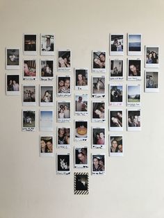 a white wall with many pictures hanging on it's side and one has a heart shaped frame in the middle