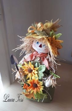 a scarecrow doll with sunflowers in a basket