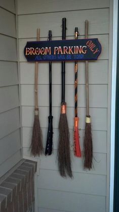 the brooms are hanging on the wall in front of the sign that says broom parking