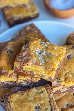 several pieces of chocolate chip cookie bars stacked on top of each other in a white plate