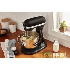 an image of a kitchen mixer with food in it on the counter top next to other ingredients