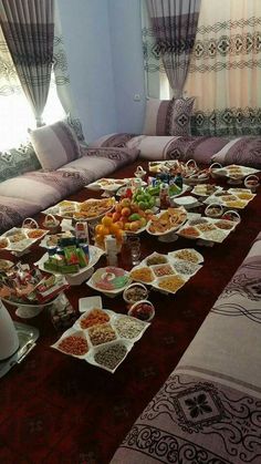 a long table filled with lots of food on top of a red carpeted floor