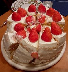 a cake with strawberries on top is sitting on a table and ready to be eaten